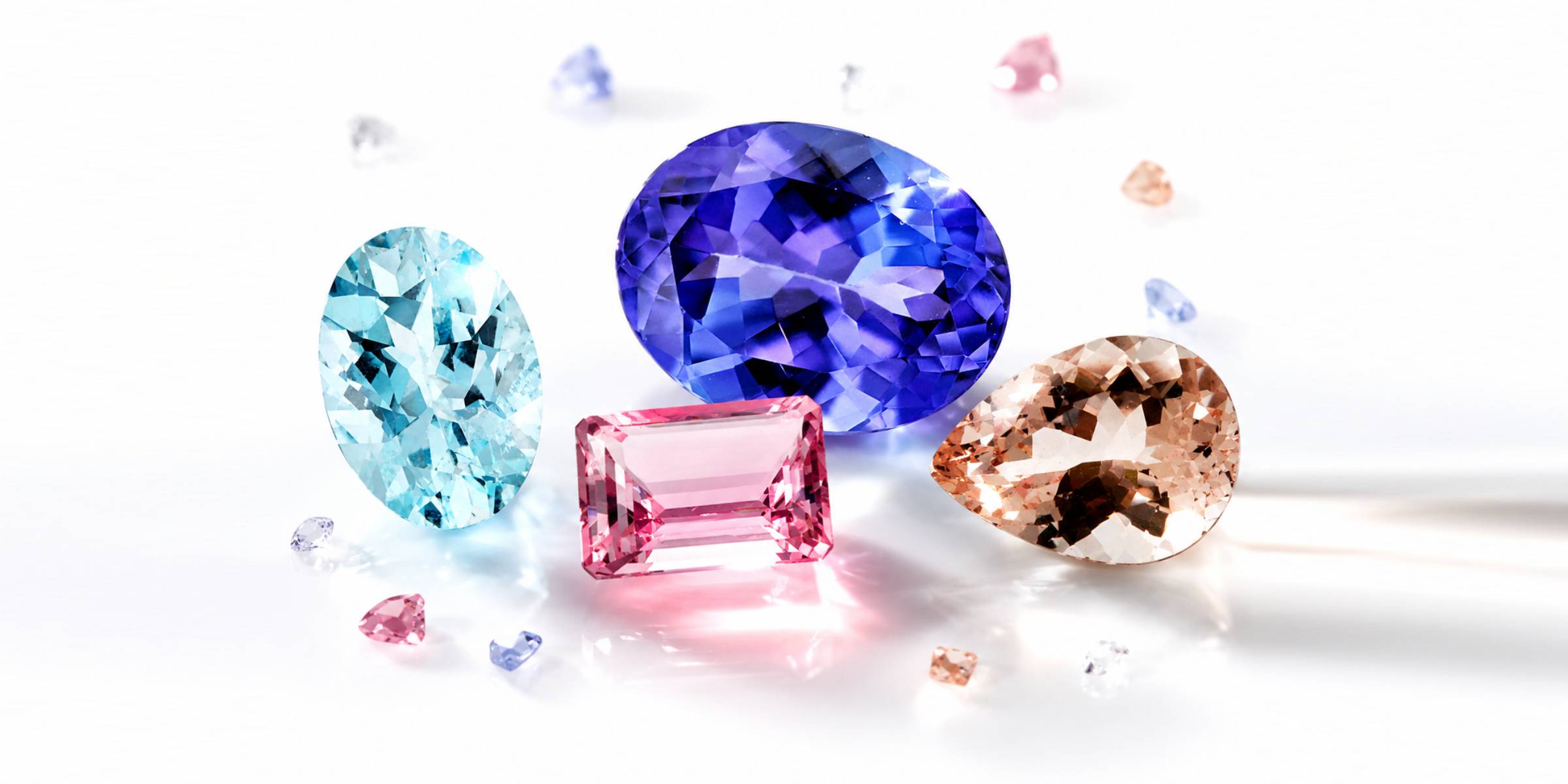 Four colorful loose gemstones on a white background