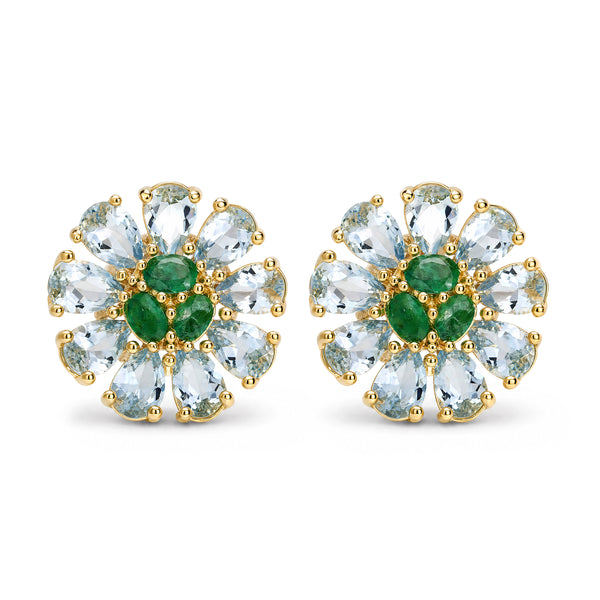 A pair of gold flower-shaped stud earrings featuring light blue marquise-cut gemstones and green oval center stones, set against a plain white background.